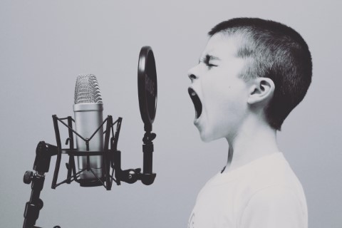 picture of child speaking into a microphone